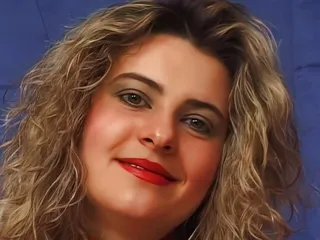 Das geile Babe mit den dicken Brüsten strippt und fingert sich die Pussy